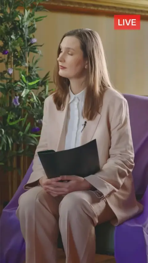 Blush pink trouser suit with white shirt, still at 41:03 in My Very Royal Romance